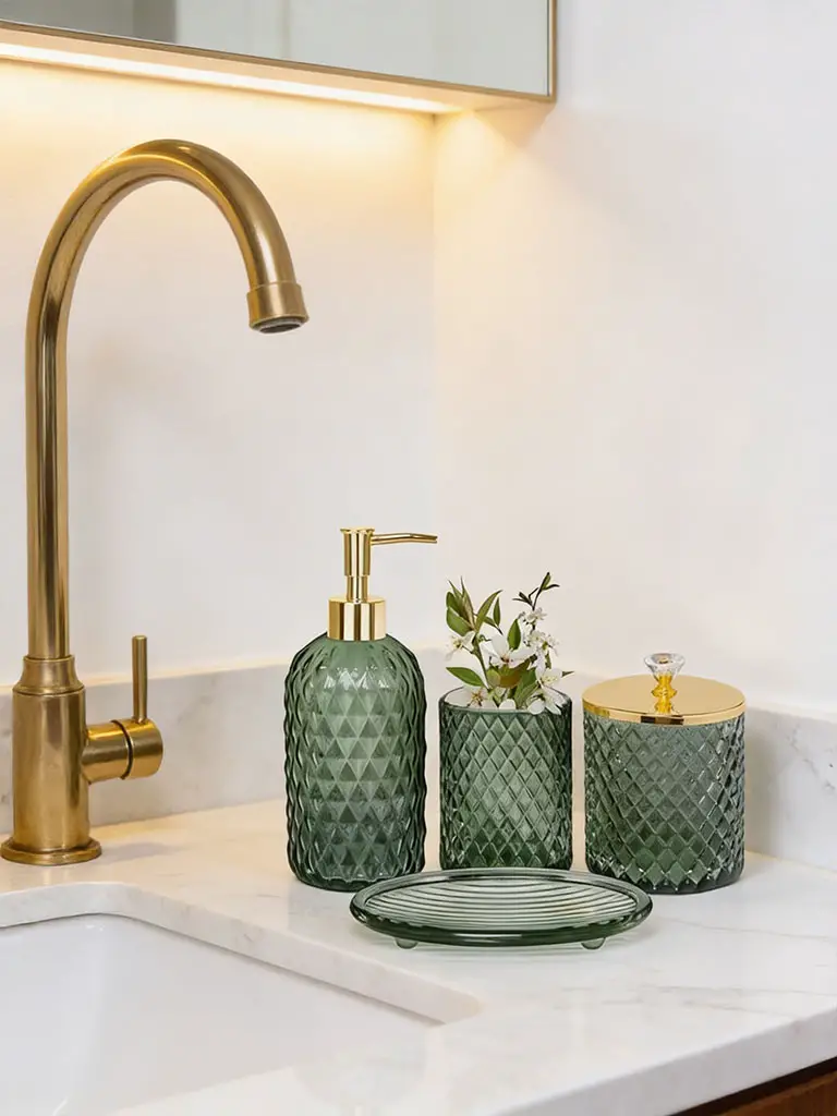 Olive green textured glass soap dispenser set with gold pump on white marble bathroom countertop.