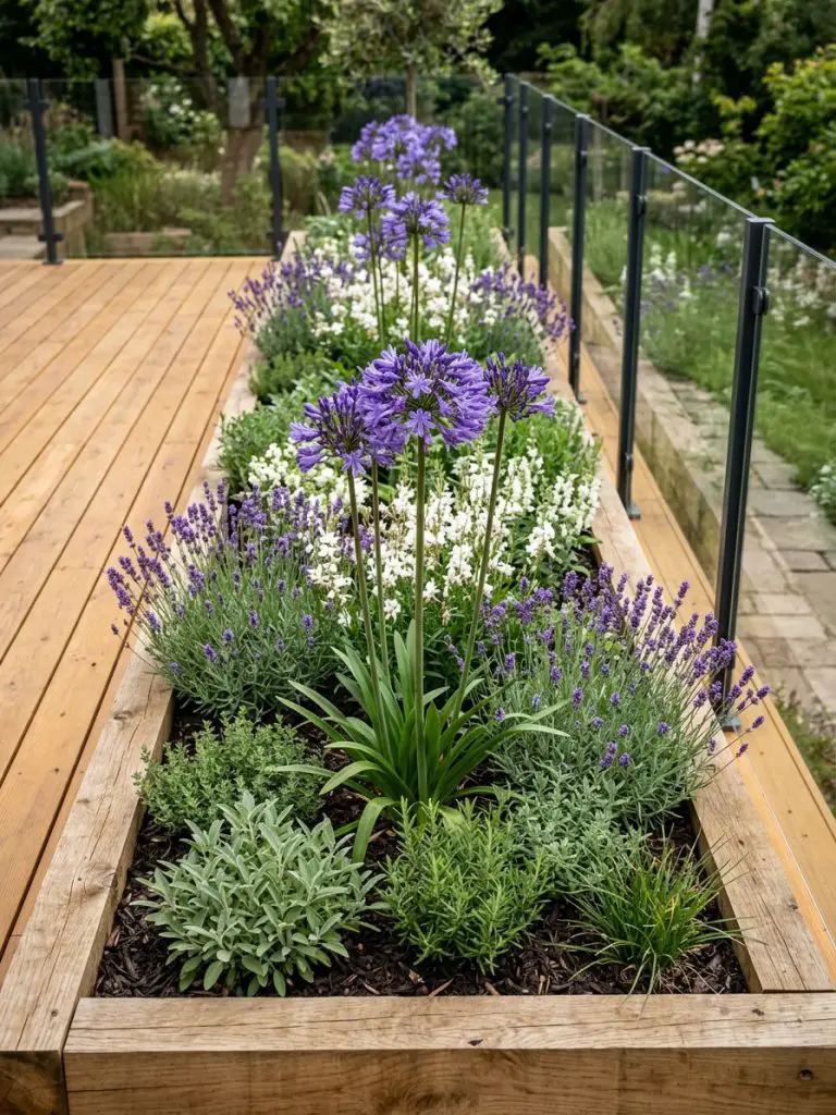 A raised wooden deckside flower bed designed in a warm minimalist and modern rustic garden style, featuring layered plantings of tall purple.