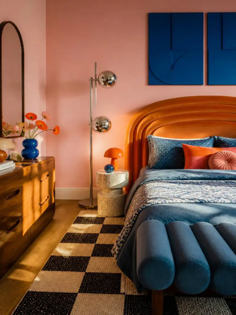 interior photography of a retro modern pink orange and blue bedroom featuring playful geometric decor and bold vintage-inspired styling.