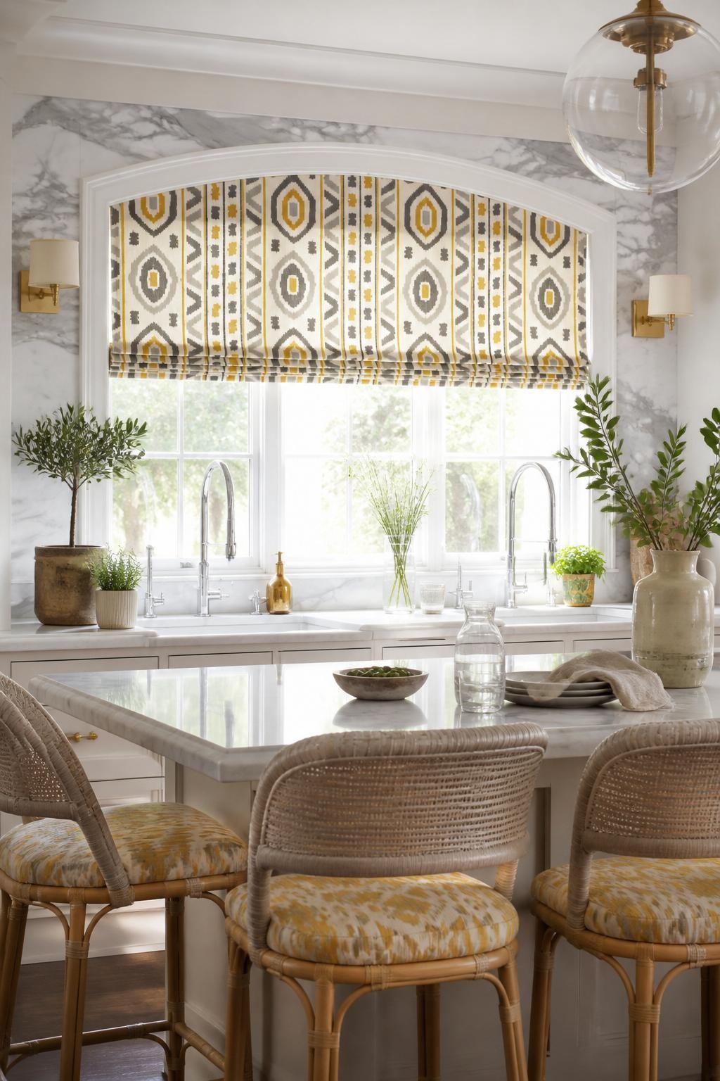 An upscale bohemian kitchen shines with a striking patterned Roman shade in a heady mix of yellow, gray, and cream, stretching across an ele.